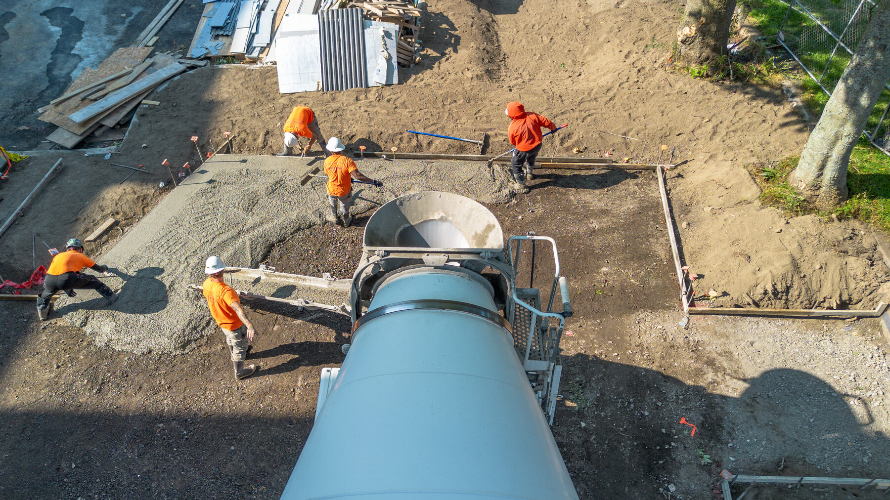 Aerial view of a crew screeding a fresh concrete pour on a residential build site